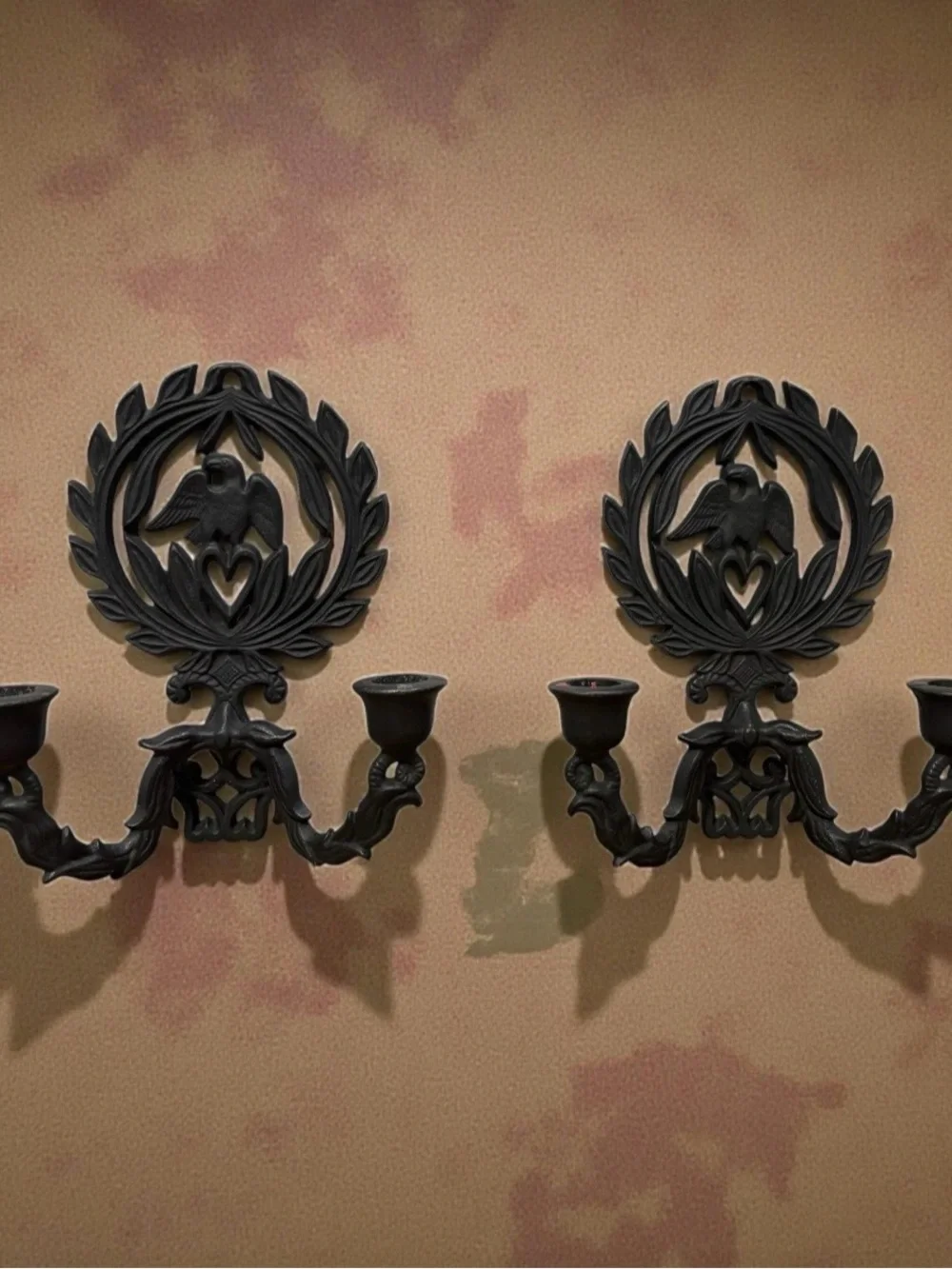 A pair of vintage cast iron wall sconces with eagle and laurel wreath motif